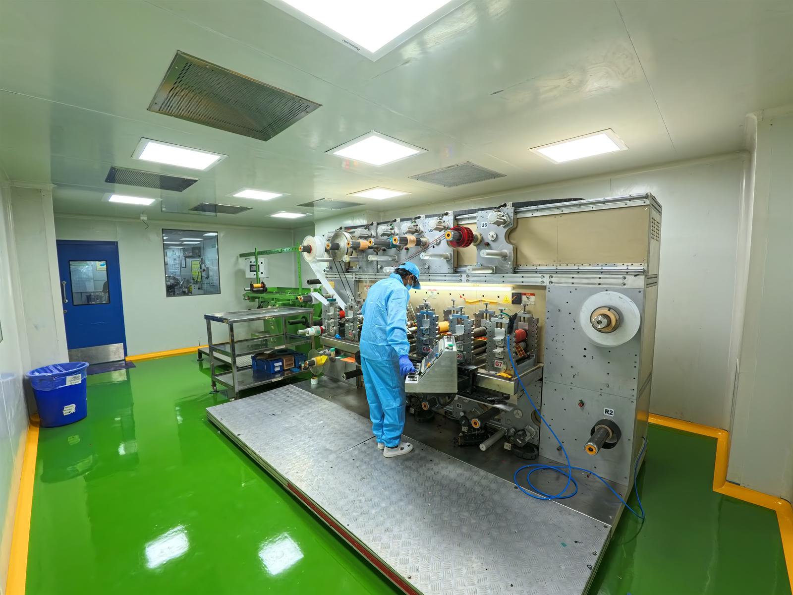 Technician operating a rotary die-cutting machine